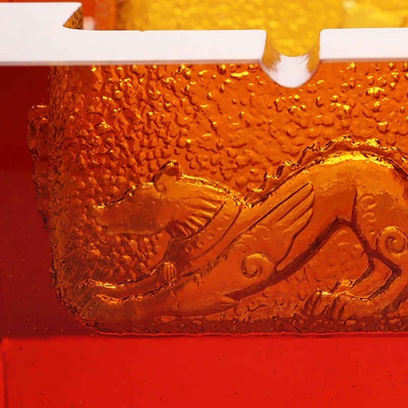 Asbak kaca berwarna merah dengan motif binatang timbul yang indah